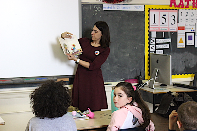 teacher showing a book to students