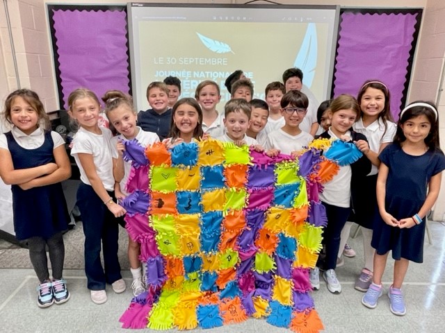 kids holding colourful quilt
