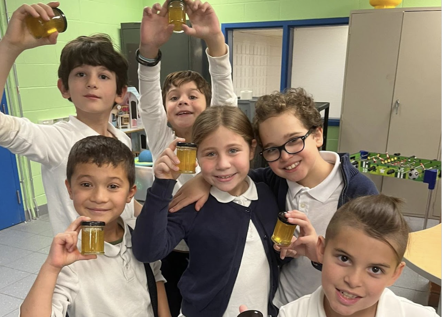 students are holding honey jars