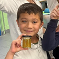 students are holding honey jars