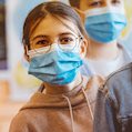 Elementary student with surgical mask on face