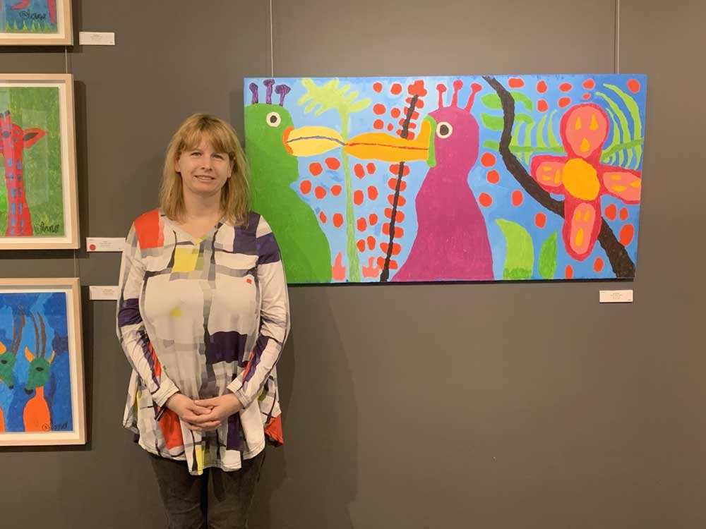 Alana Barrell poses in front of her "Birds" painting at CAP Gallery in Montreal, on display as part of her Fabulous Bestiary exhibition. Photo: J. Stoopler