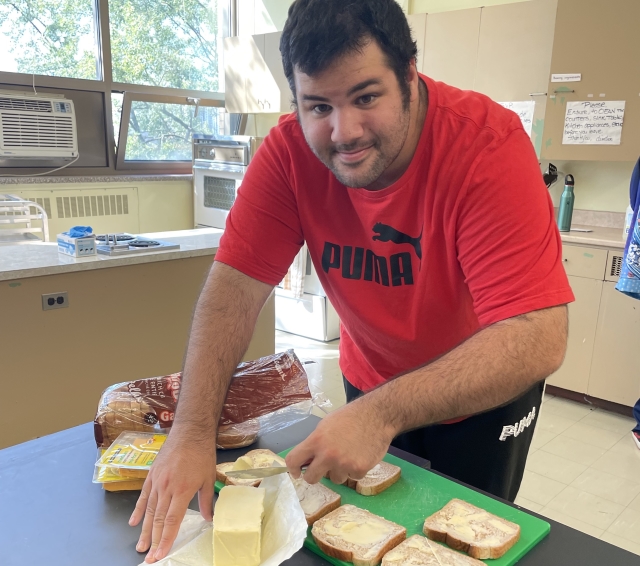 Alex Ponte, a student in the SVI program, learns to make a meal in the kitchen.