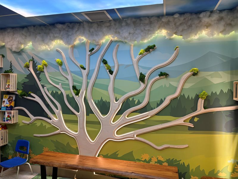 The waiting area features interactive three-dimensional trees and animals that light up the room and adjacent hallways, all set against colourful nature and city scenes.  