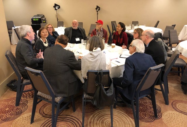 Group of attendees sitting at round table during group breakout sessions at the Access to Care Symposium
